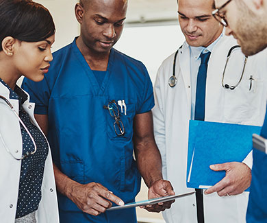 Four physicians looking at the paper