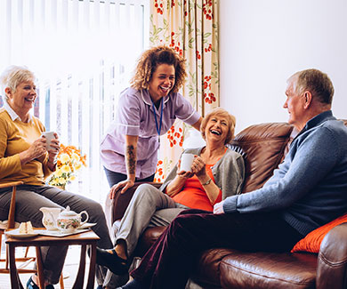 A Nursing Home clinician laughing with a male and a female patient