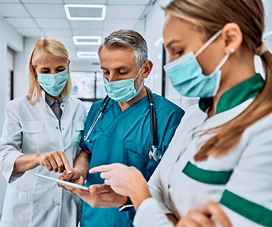 Three physicians are looking at the iPad