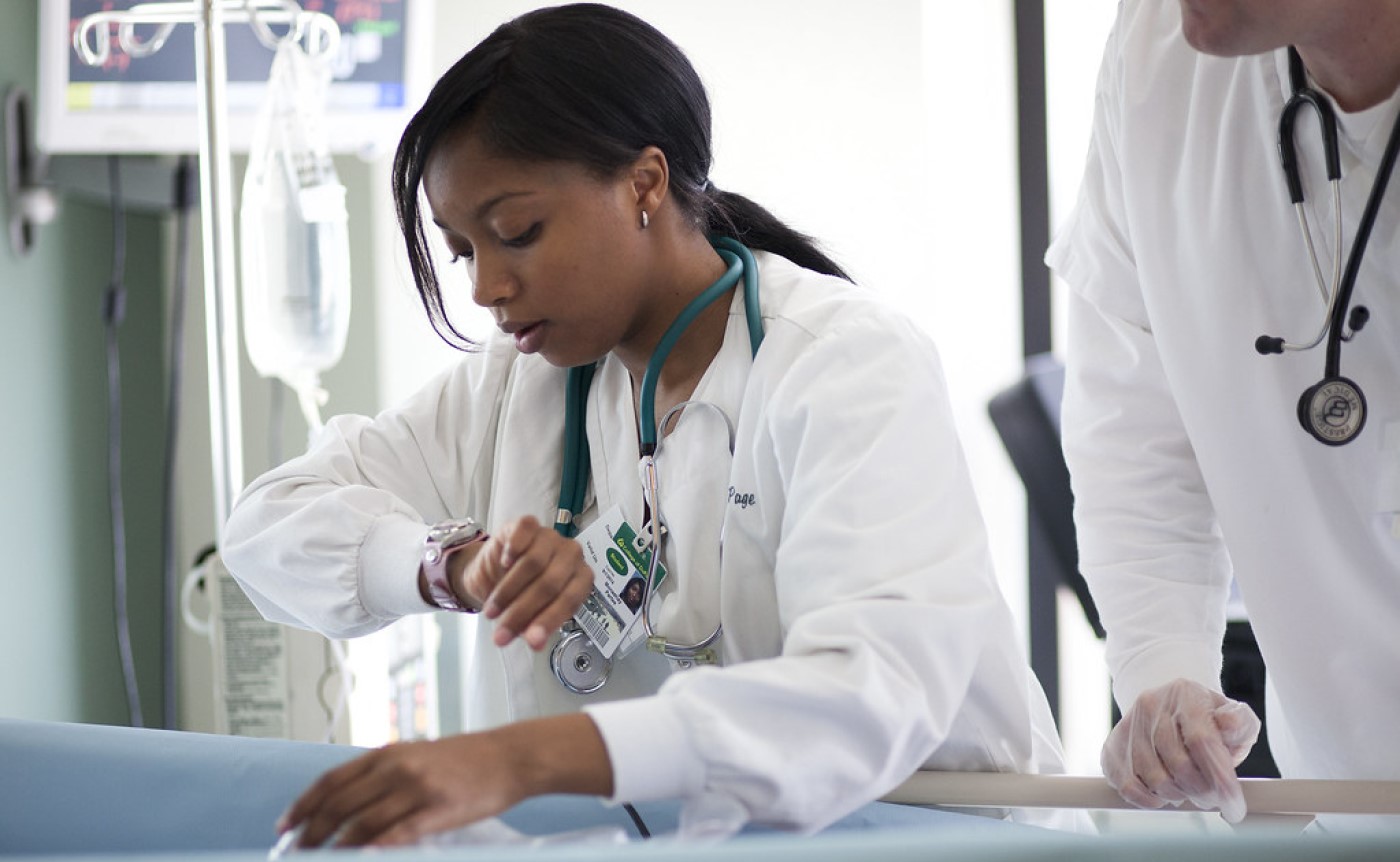 ER Doctor checks watch while attending patient