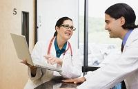 2 doctors having a discussion over a laptop