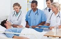 Doctors talking to a patient in a hospital bed