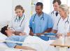 4 doctors standing around a patient's bed