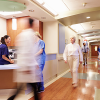 hospital personnel moving quickly past a nurses' station