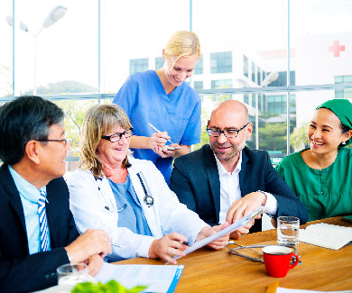 Medical professionals gathered around, listening to a presentation