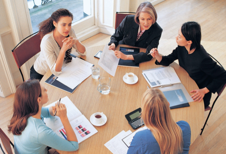 Group of women sitting around a table in discussion