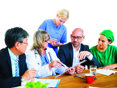 Photo of clinical and administrative staff talking about patient records. 